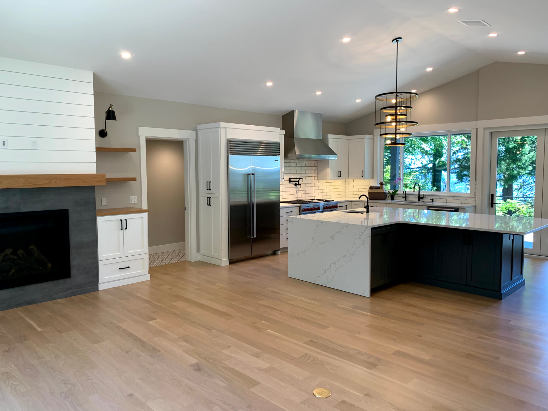 Open concept kitchen and living area with modern lighting