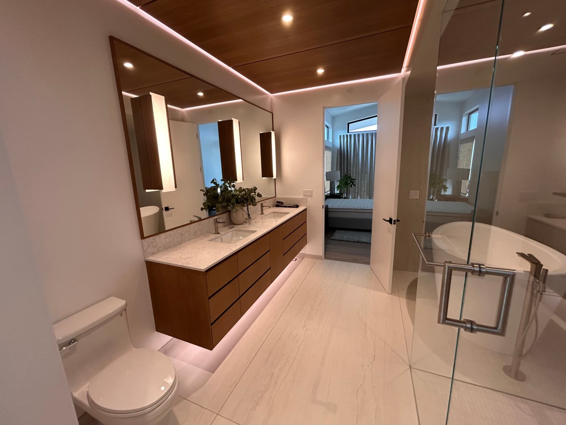 Bathroom with wood ceiling, backlit mirror and LED cove lighting